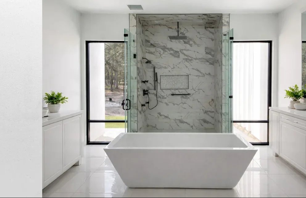 Modern master bathroom with frameless glass shower and freestanding tub
