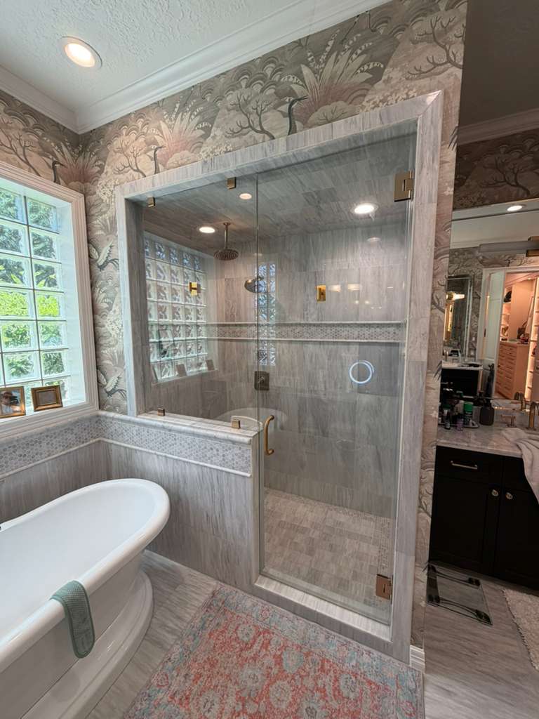 Frameless shower enclosure with glass block window and freestanding tub